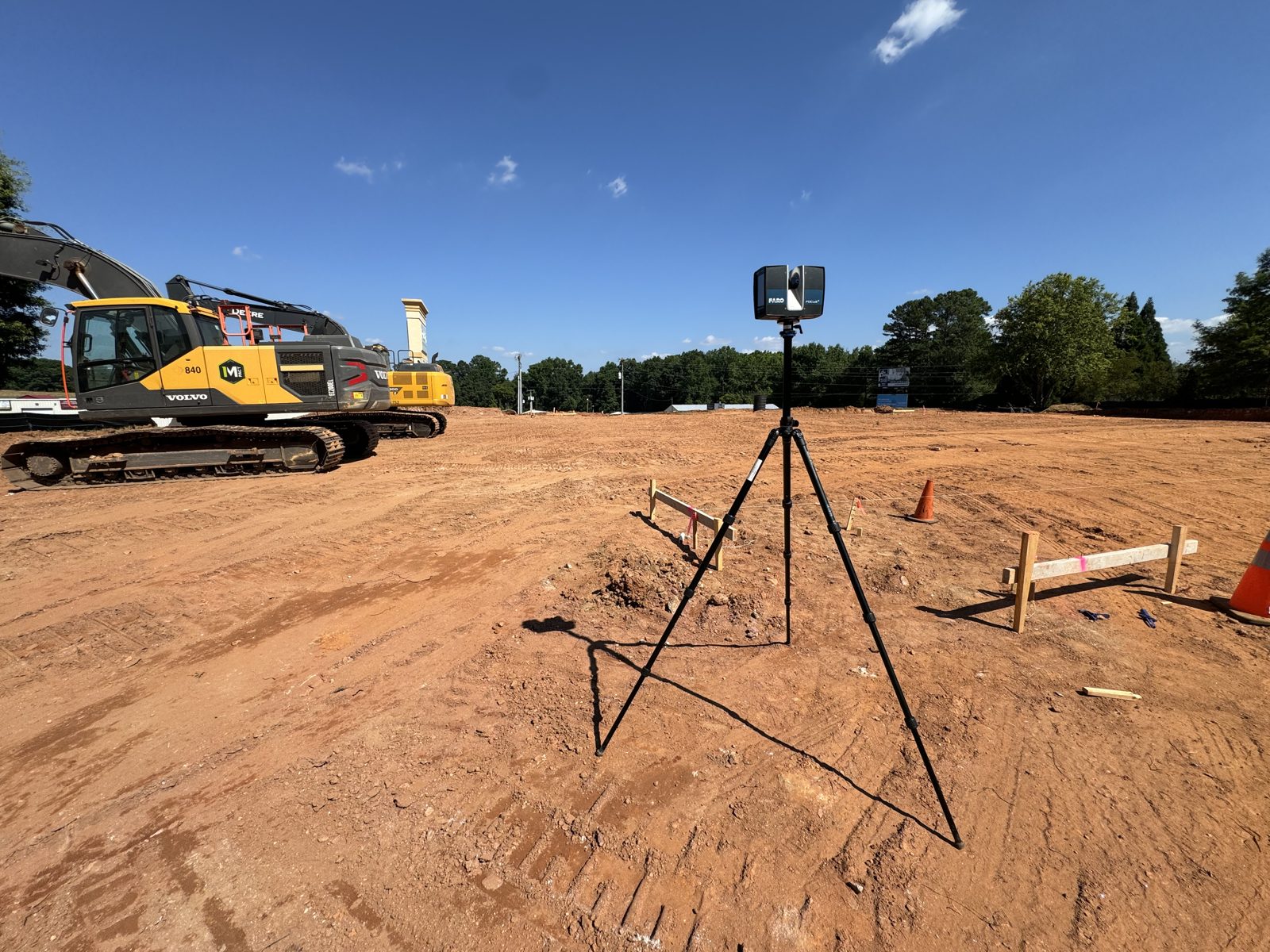 Laser scanner on an excavation site with an excavator